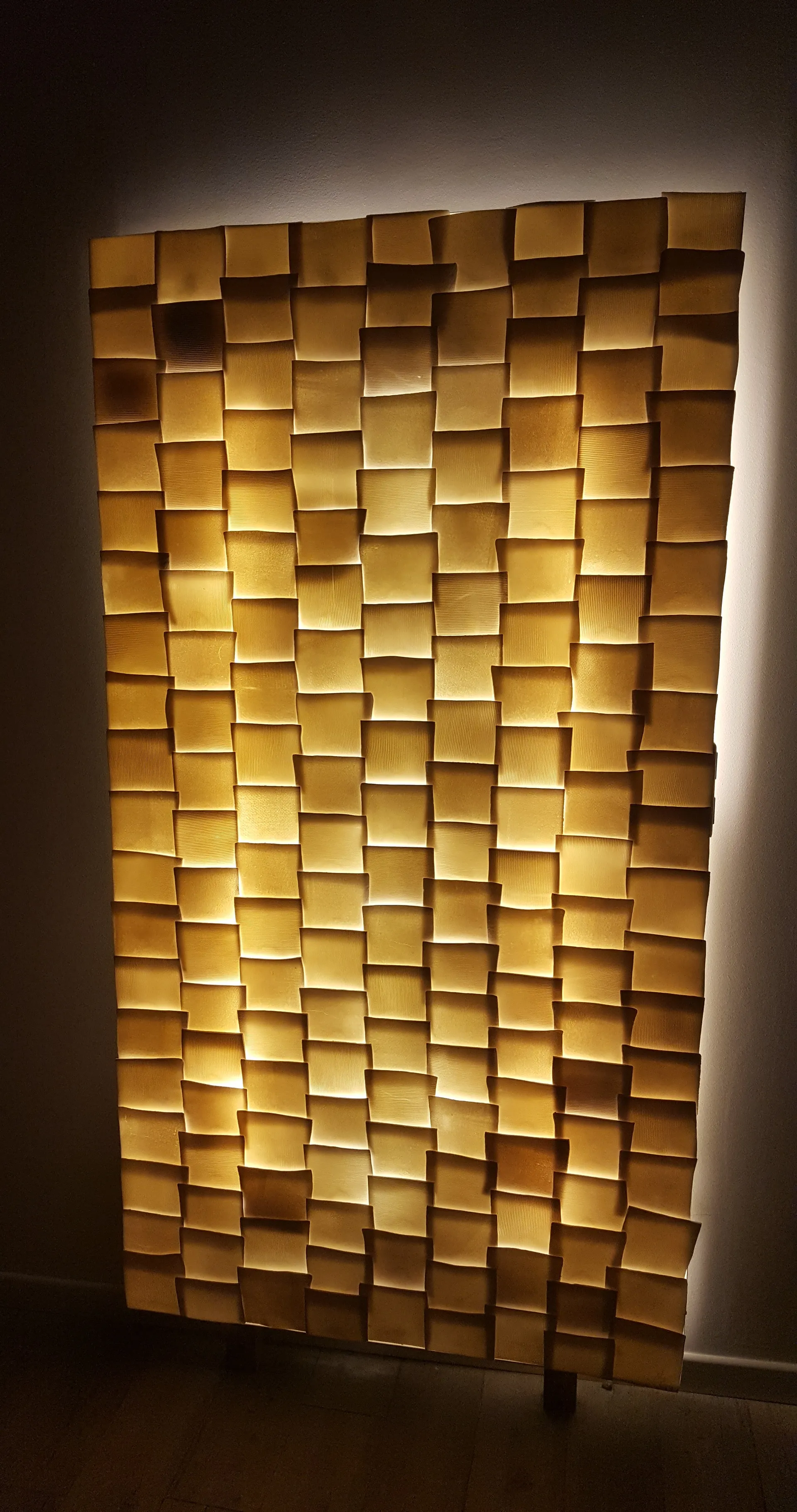 Paralight, grand panneau vertical couvert de petites plaques de porcelaine décalées et rétro-éclairées.