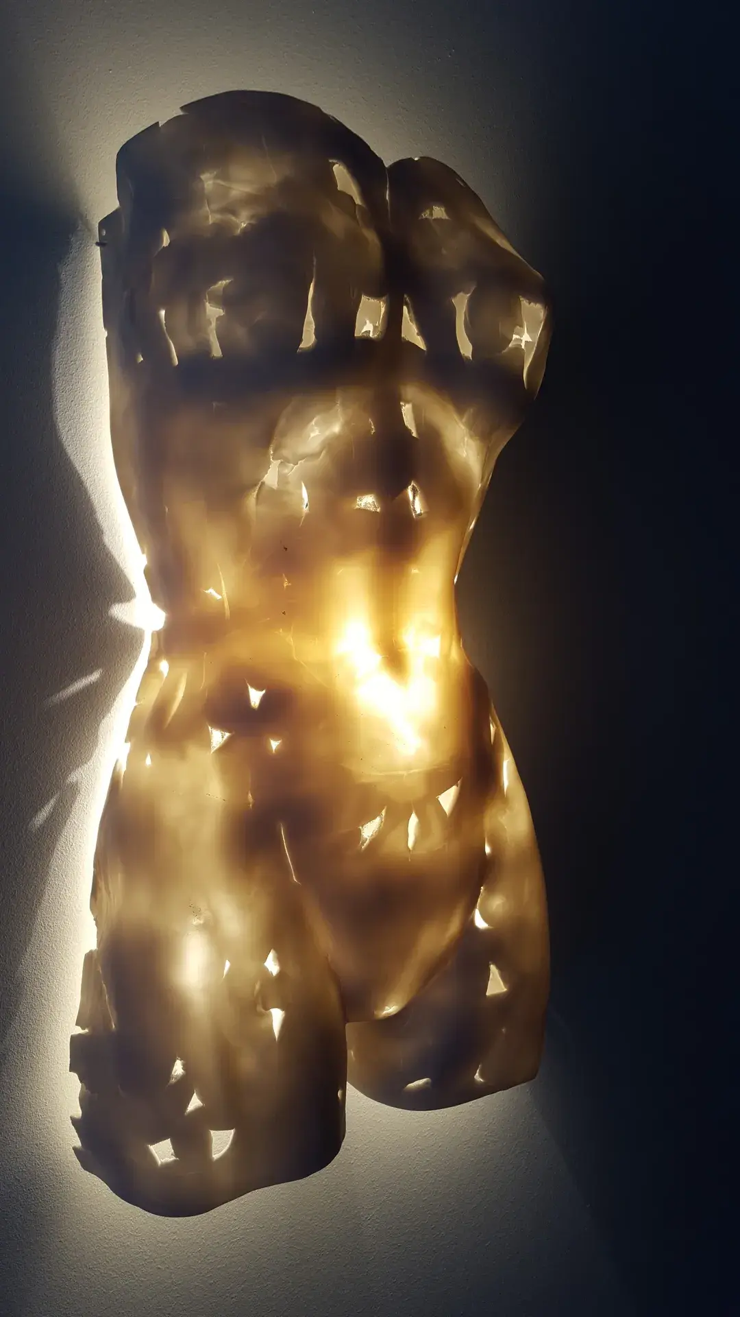Tribale, deux formes allongées de porcelaine ajourée réunies par une lumière blanche centrale.